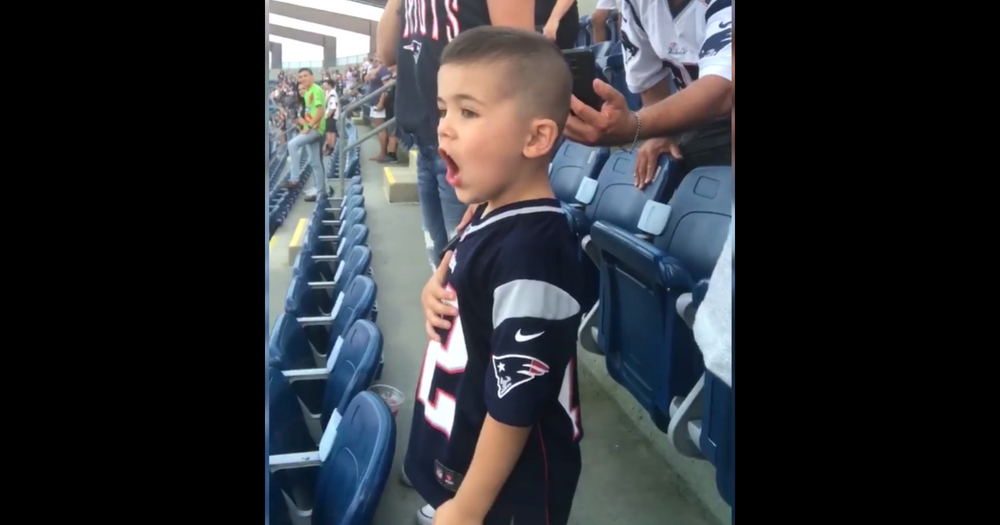 Little boy wearing Patriots jersey singing loudly