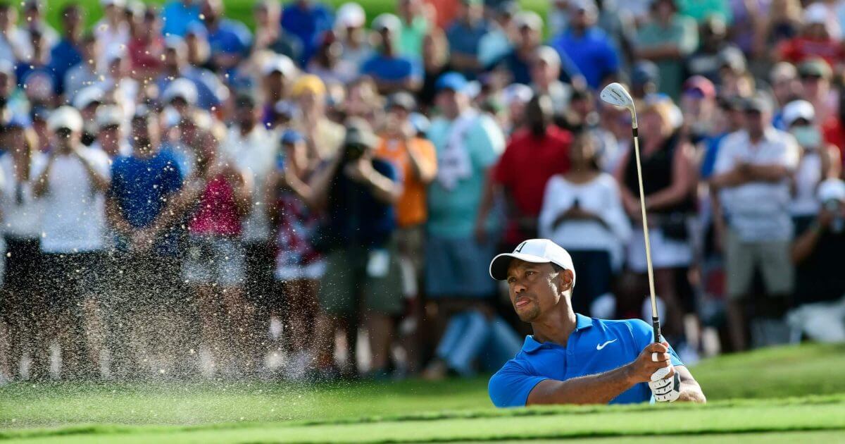 Tiger Woods hits out of the sand to the 15th green during the third round of the Tour Championship golf tournament Saturday in Atlanta.