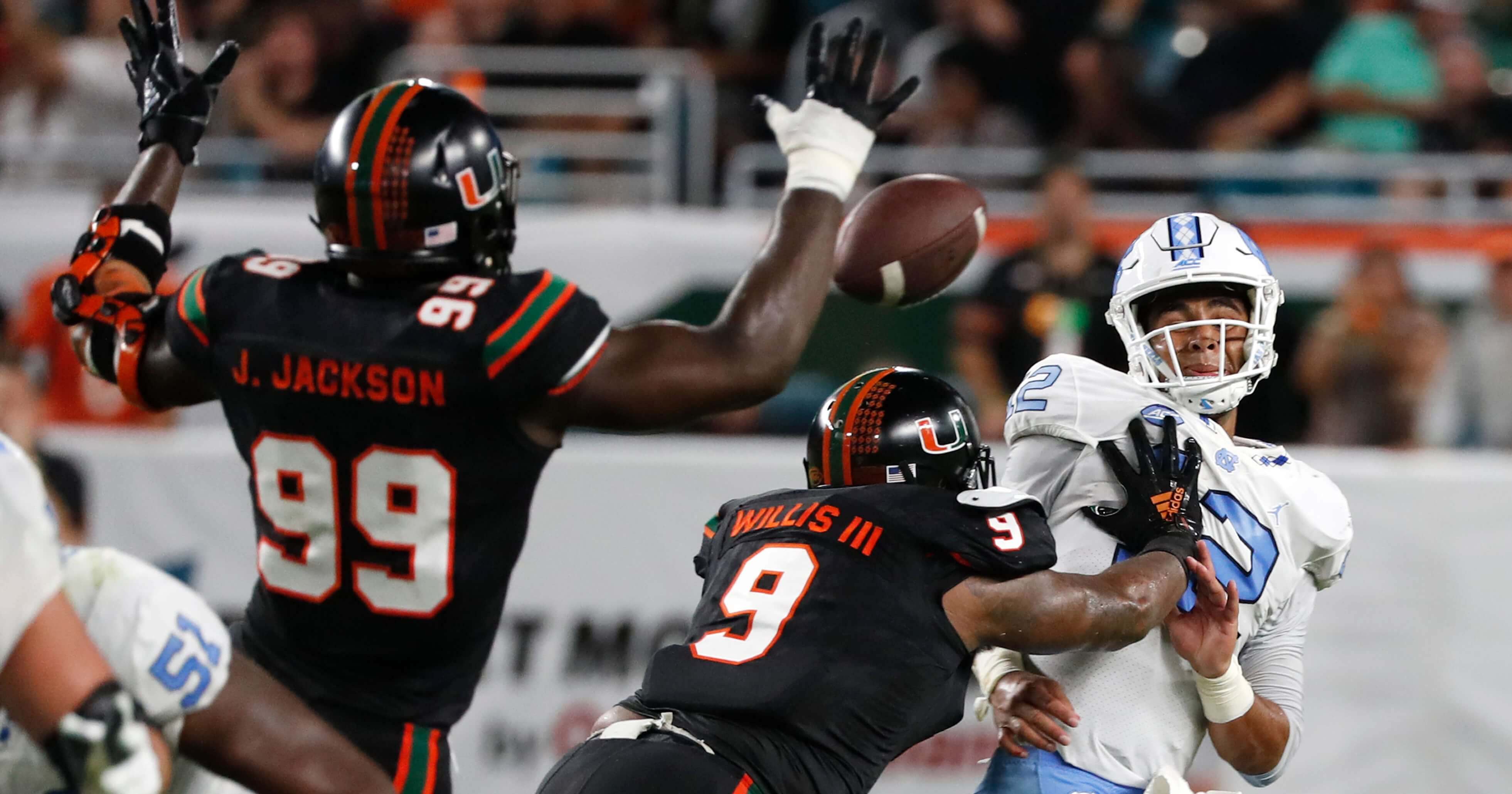 Miami defensive linemen Joe Jackson (99) and Gerald Willis III (9) rush North Carolina quarterback Chazz Surratt (12) as he attempts to pass during the first half of the Hurricanes' home game Thursday night.
