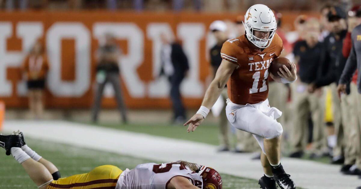 Texas quarterback Sam Ehlinger (11) works to stay in bounds as he runs past Southern California linebacker Porter Gustin (45) Saturday in Austin, Texas.