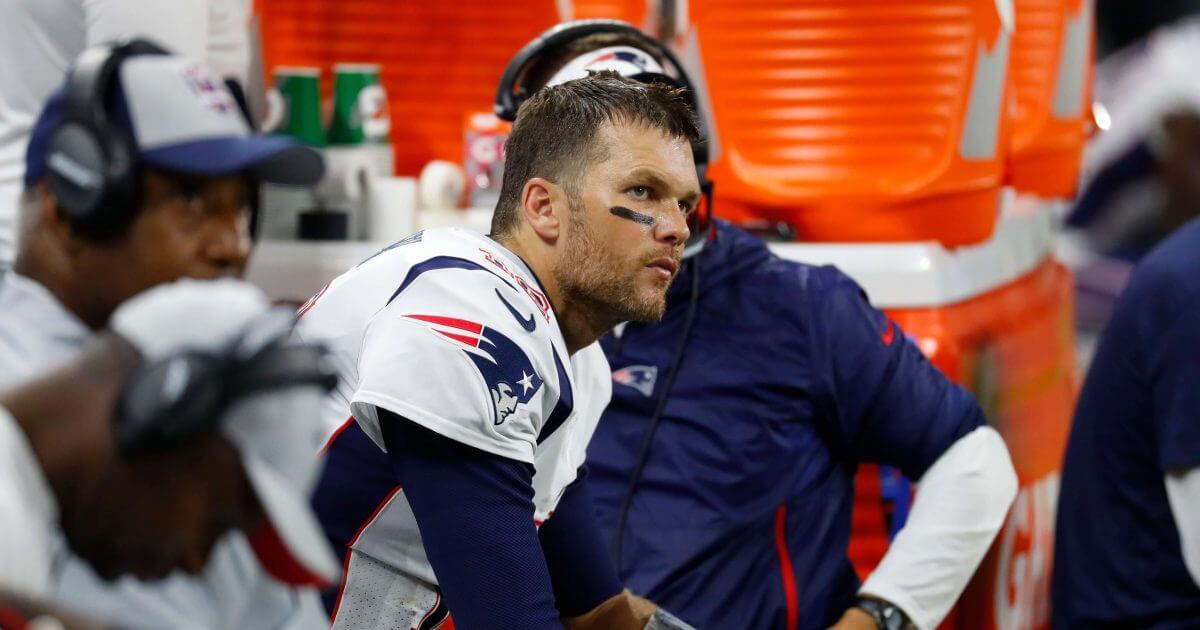 New England Patriots quarterback Tom Brady sits on the bench Sunday night during the second half of his team's 26-10 loss at Detroit.