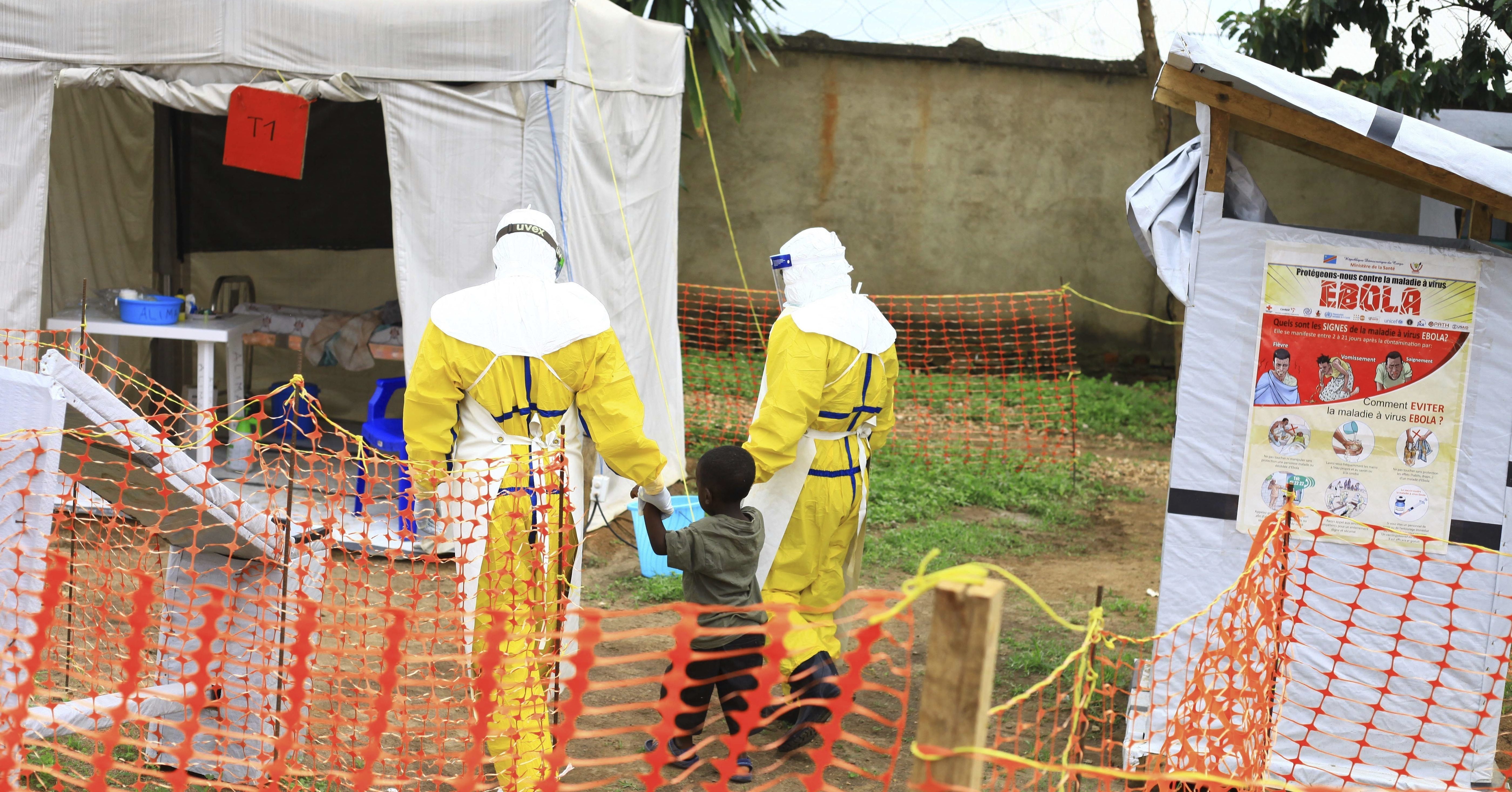 Health workers walk with a boy suspected of having the Ebola virus Sept. 9 at an Ebola treatment center in Beni, Eastern Congo.