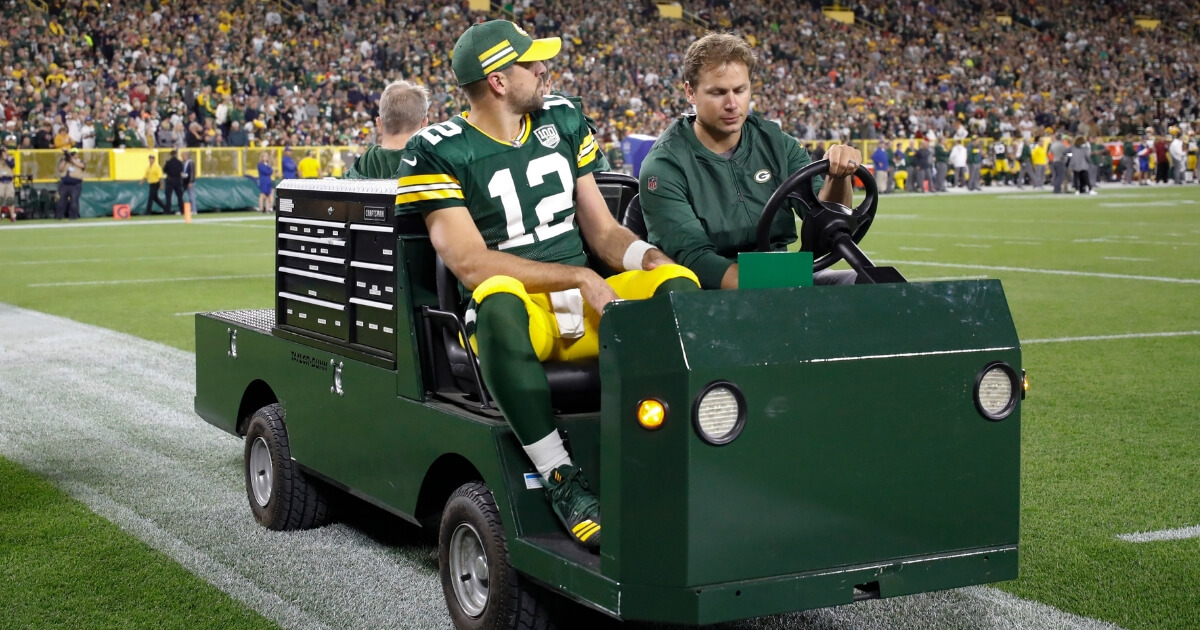 Packers quarterback Aaron Rodgers is taken off the field on a cart after injuring his leg during the first half of Sunday's game against the Chicago Bears in Green Bay.
