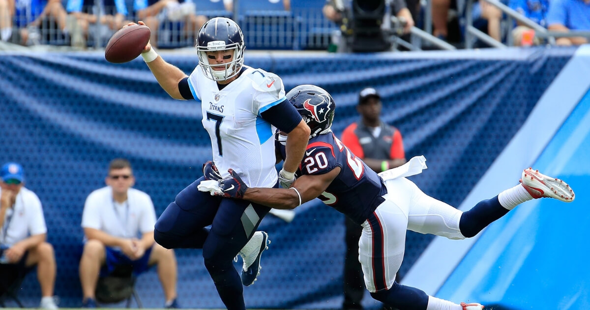 Blaine Gabbert (7) of the Tennessee Titans is tackled by Justin Reid of the Houstan Texans during the second quarter of Sunday's game in Nashville.