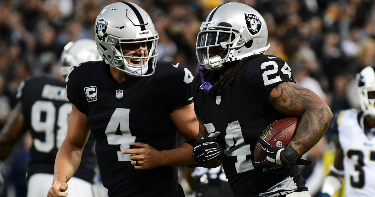 Derek Carr, left, celebrates with Oakland Raiders teammate Marshawn Lynch after a touchdown against the Los Angeles Rams on Monday night at Oakland-Alameda County Coliseum.