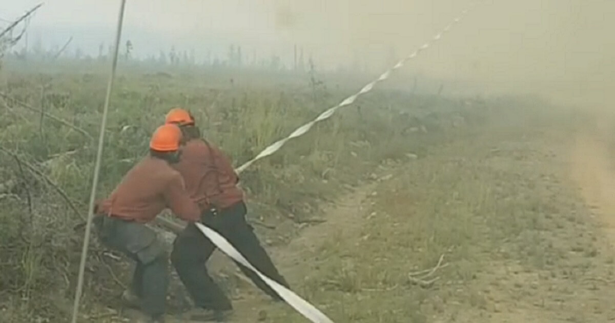Firefighters in British Columbia, Canada, struggle to hold onto their hose against the might of a "firenado," a vortex of flames.