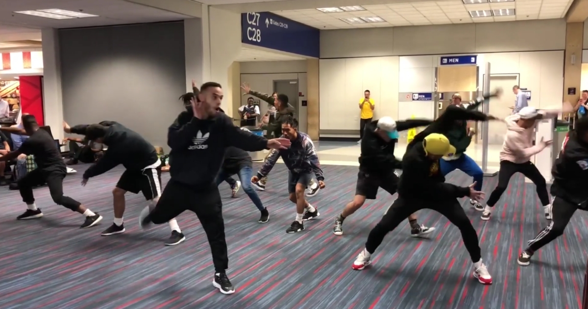 A group of people dancing in the airport.