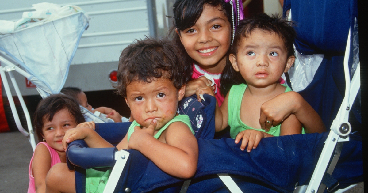 Latino children pose in a stroller in California