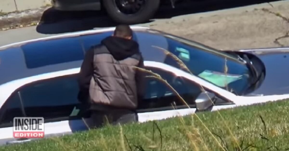 A car burglar prepares to break into a "bait" car left by "Inside Edition" on a San Francisco street to catch thieves. T