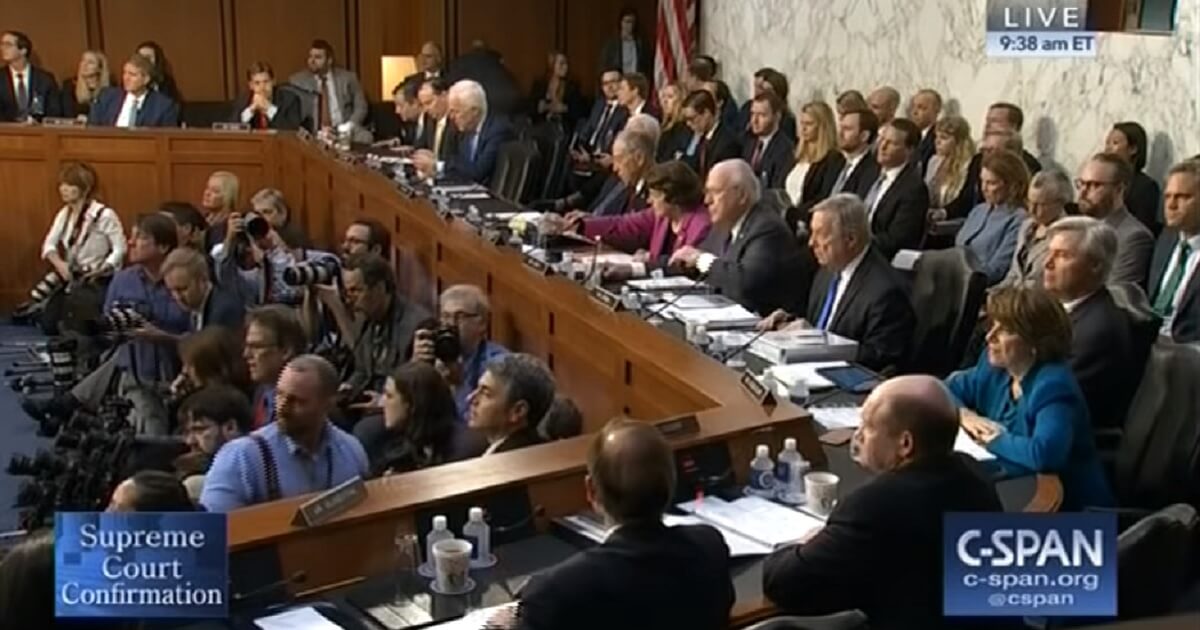 The media and Senate Judiciary Committee react to a disurbance from the audience.