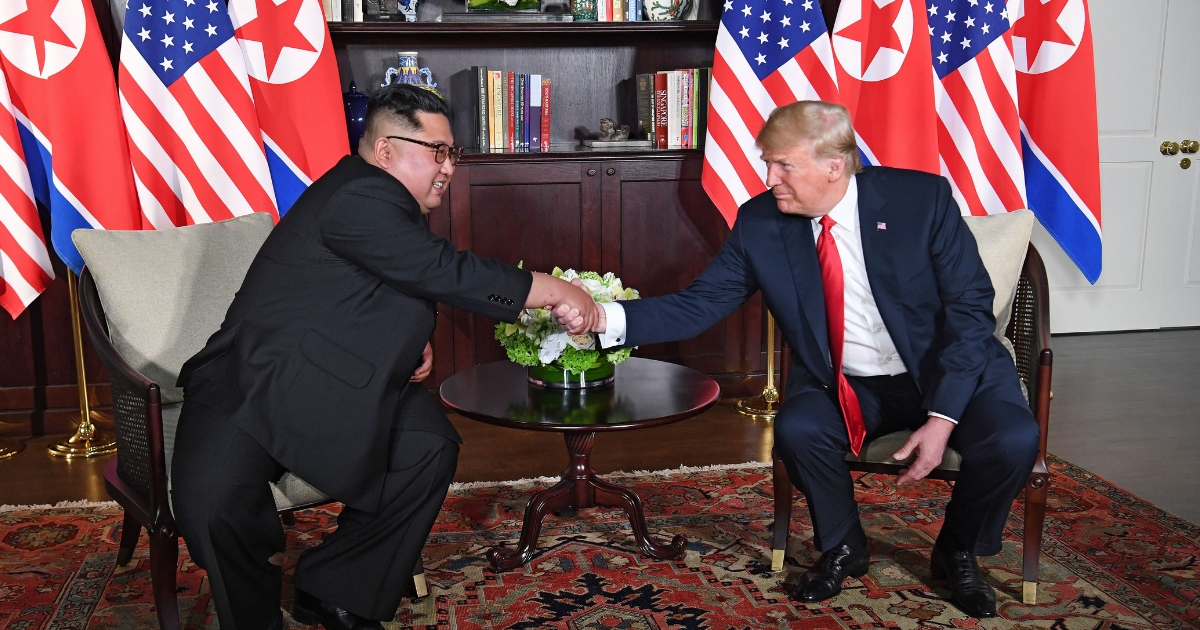 U.S. President Donald Trump, right, shakes hands with North Korea's leader Kim Jong Un, left, as they sit down for their historic U.S.-North Korea summit.