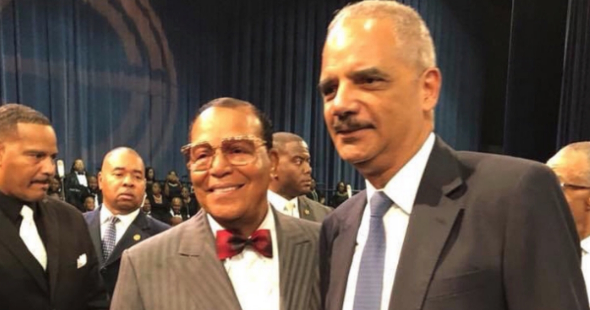 Eric Holder (right) poses for a picture with Louis Farrakhan (left) at Aretha Franklin's funeral.