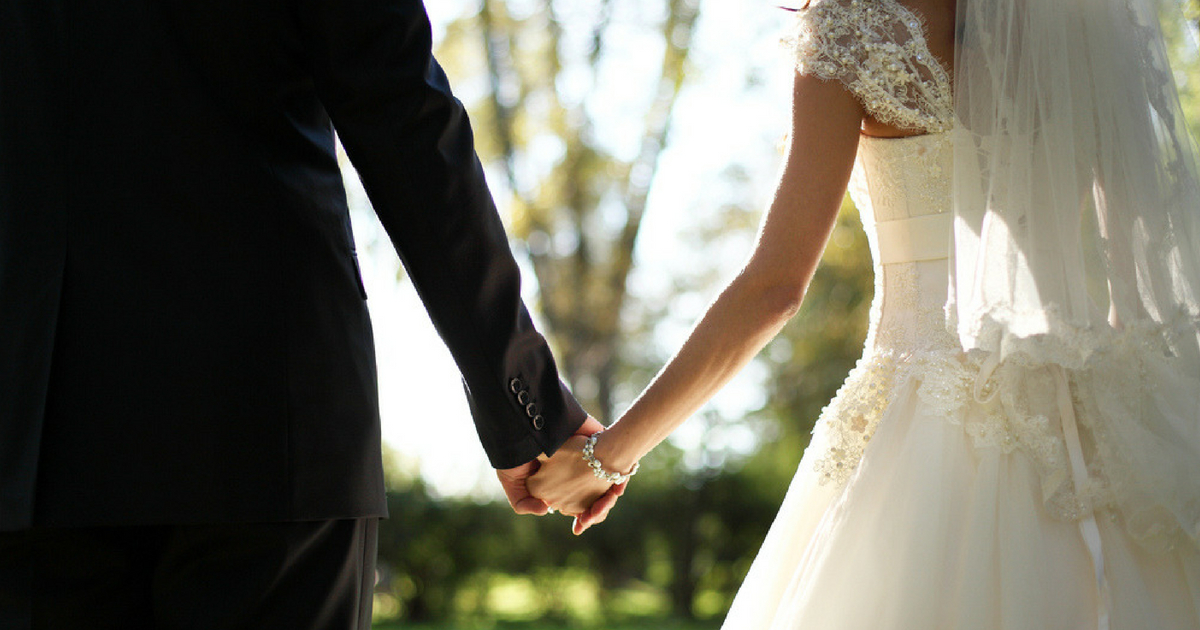 A bride and groom hold hands on their wedding day.