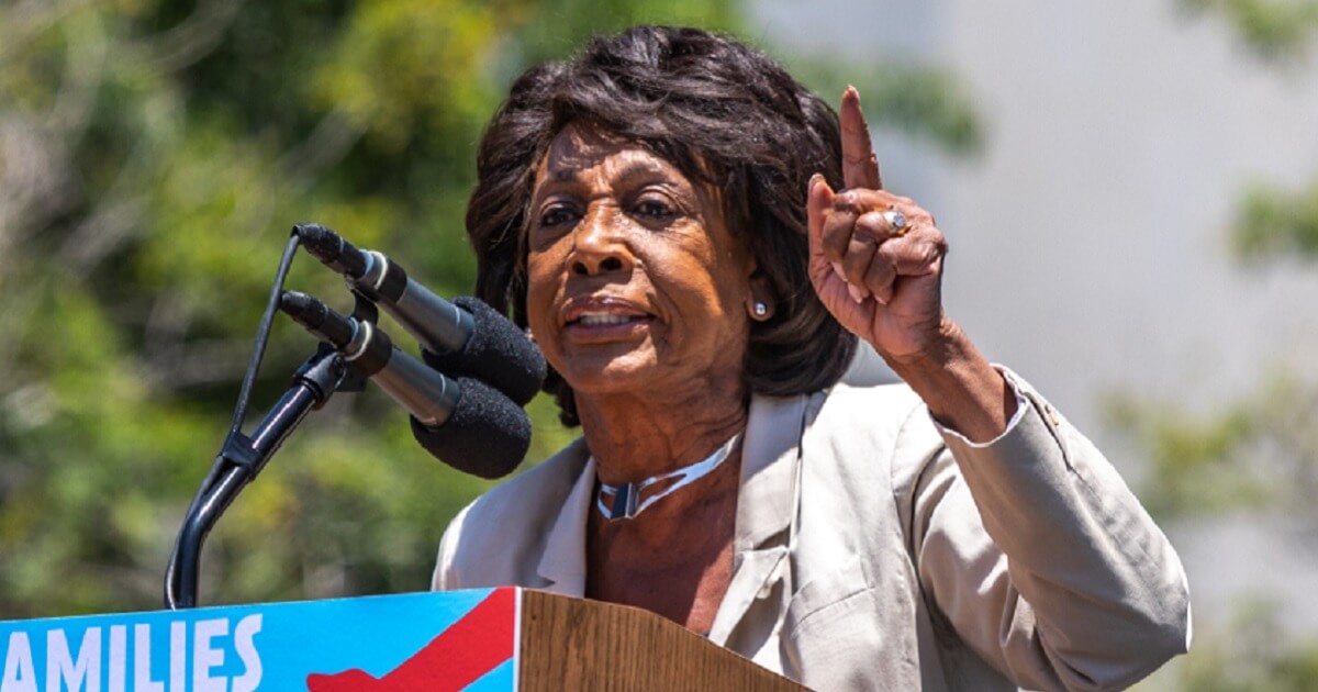 Maxine Waters points her finger while speaking from a podium