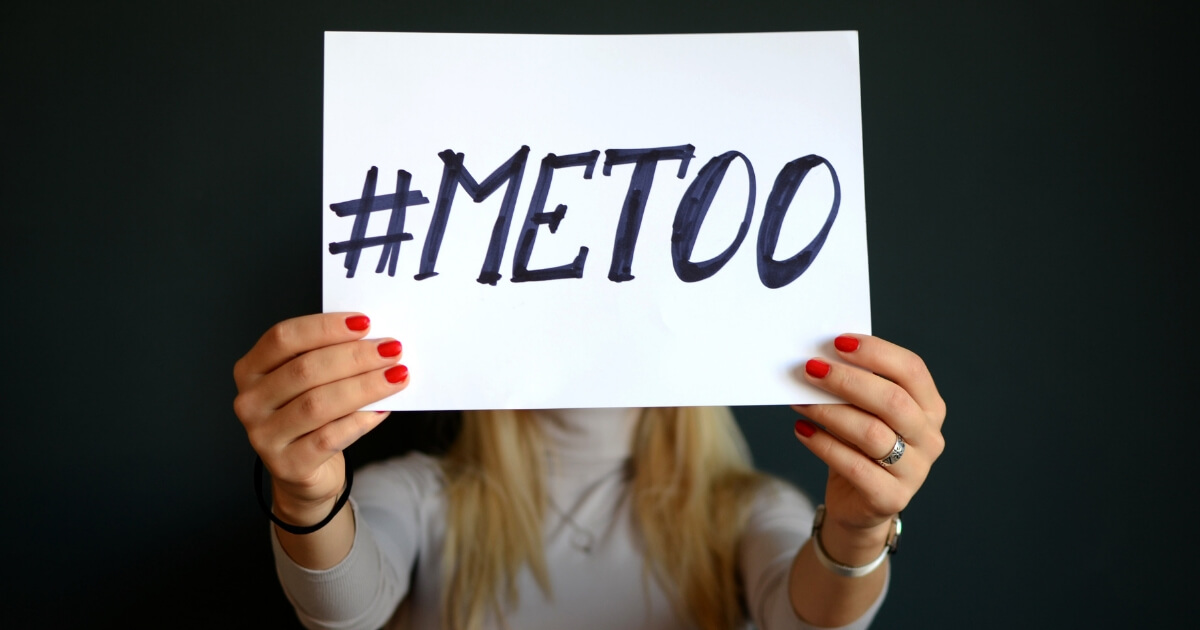 A woman holds a "#MeToo" sign.