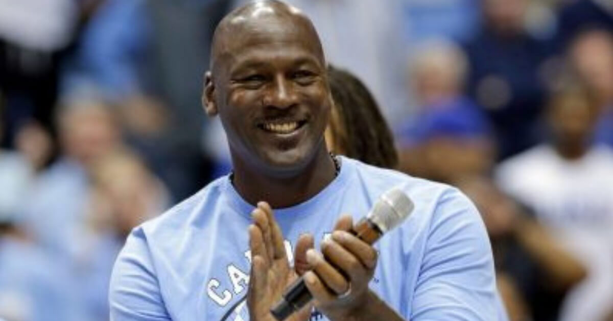 Michael Jordan applauds while watching a University of North Carolina basketball game.