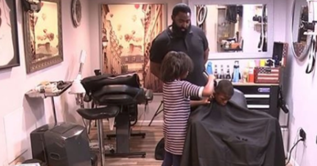 A little girl cuts a little boy's hair.