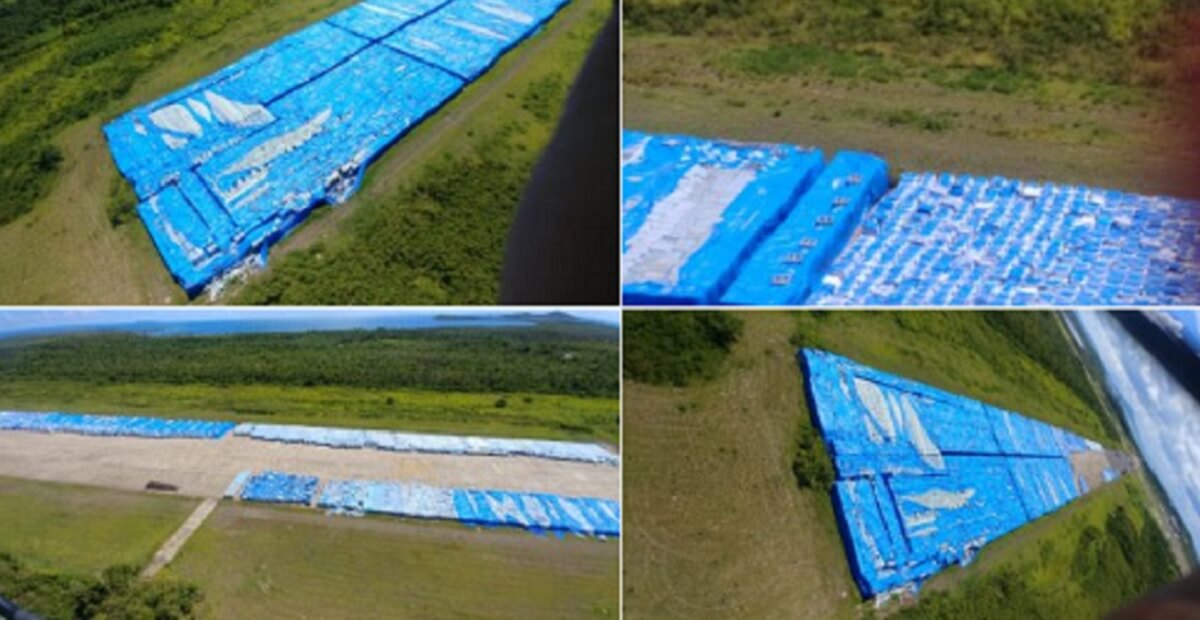 Blue tarp covers pallets of water seen from the air.