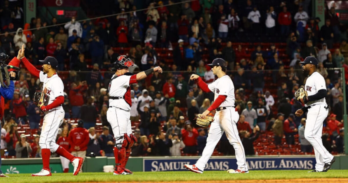 The Boston Red Sox high-five each other after defeating the Baltimore Orioles for their franchise-record 106th win Monday at Fenway Park.