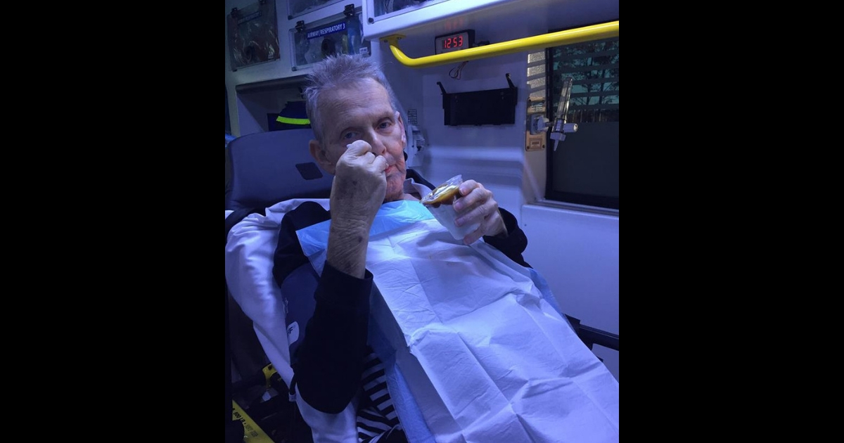 A man eats a carmel sundae inside of an ambulance on his way to the hospital.