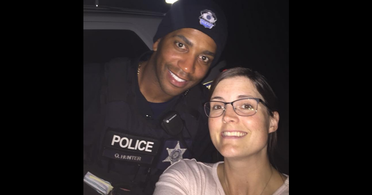 A woman with a police officer who made sure she got through the dark parking lot safely.