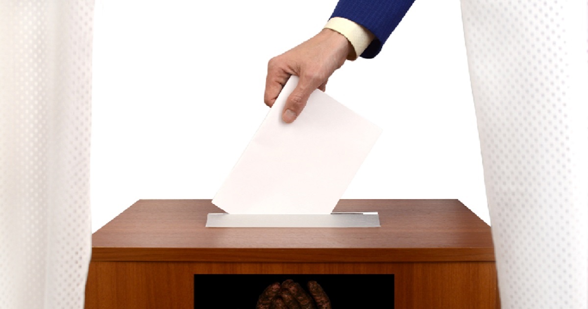 A paper ballot going into a ballot box.