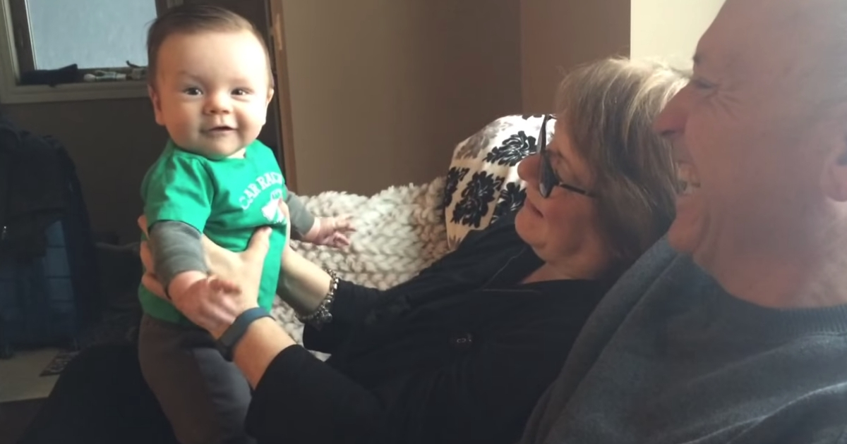 Baby is held by his grandparents and says his first word.
