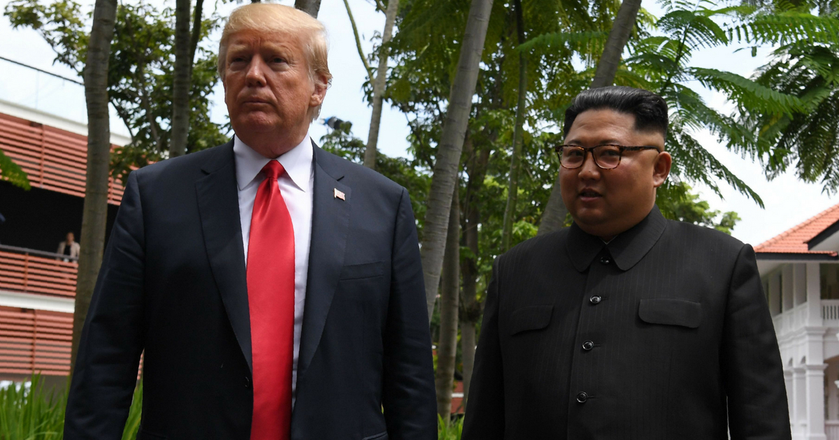 President Donald Trump walks with Kim Jong Un