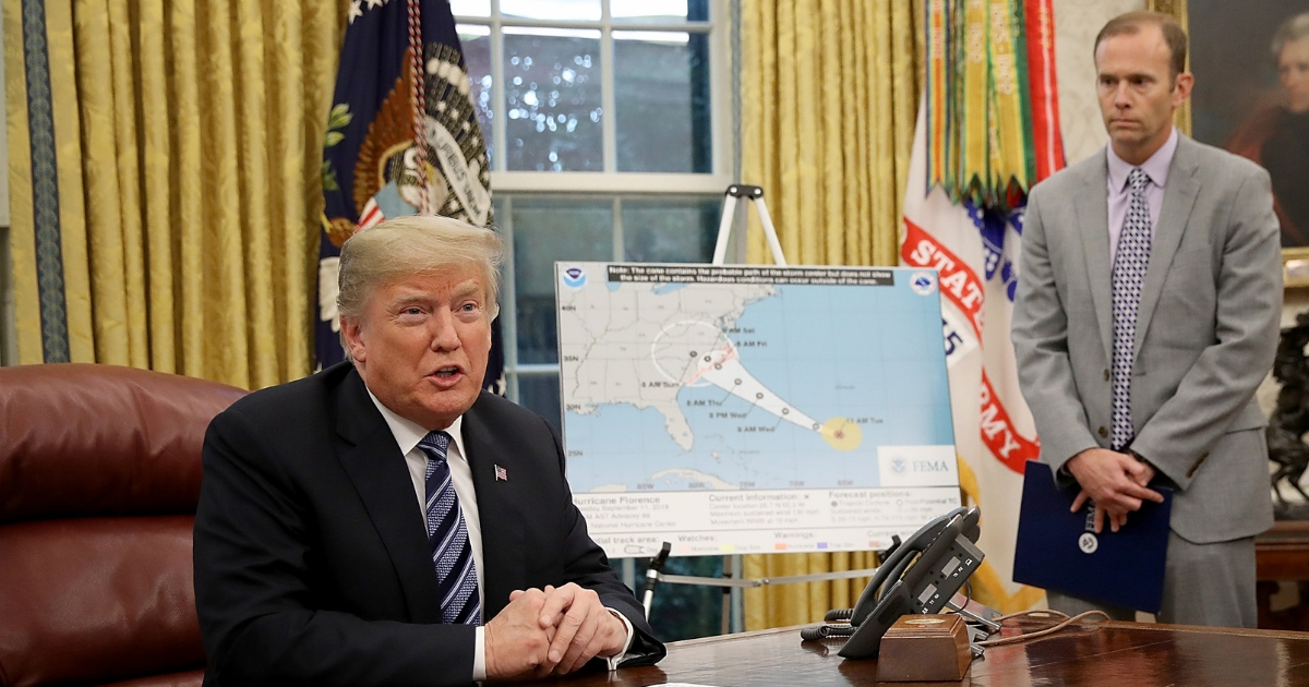 President Donald Trump (L) speaks while meeting with FEMA Administrator Brock Long in the Oval Office.