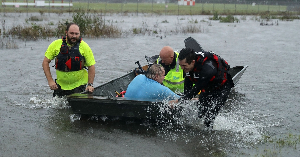 Volunteers from the Civilian Crisis Response Team rescue a man with chest pains from his flooded home