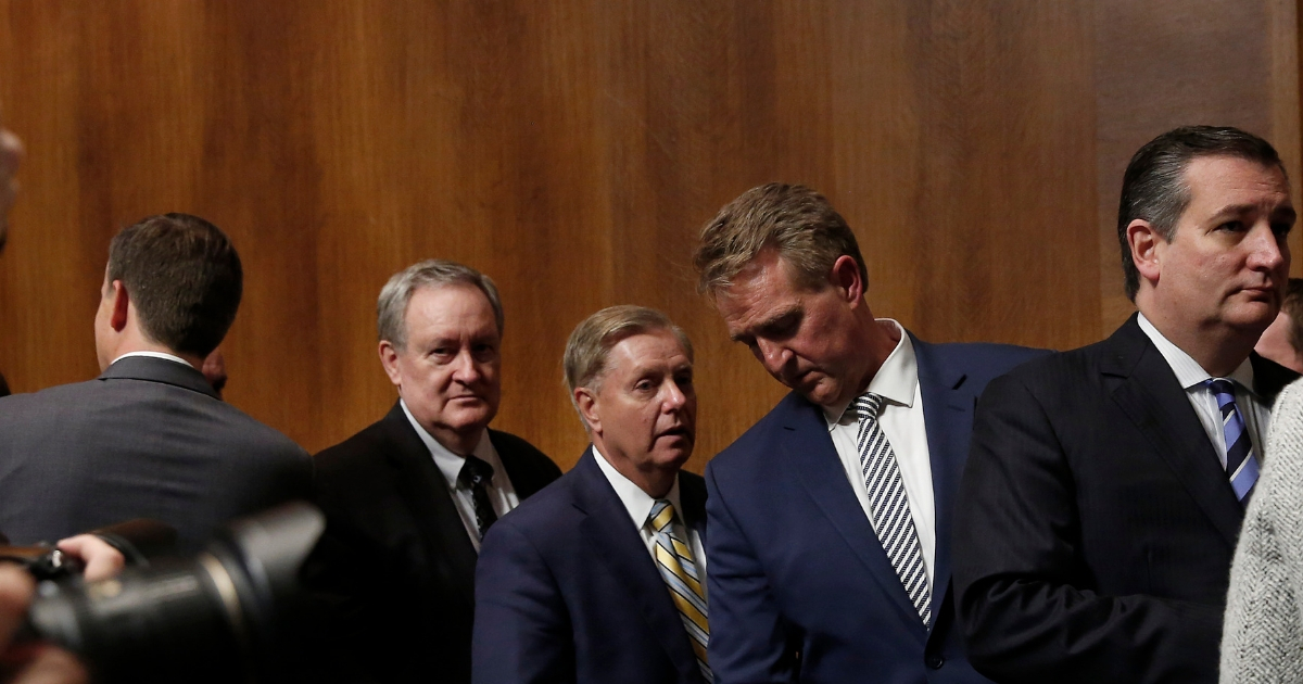 Sen. Jeff Flake (2nd right) confers with Sen. Lindsey Graham (center) following a Senate Judiciary Committee meeting.