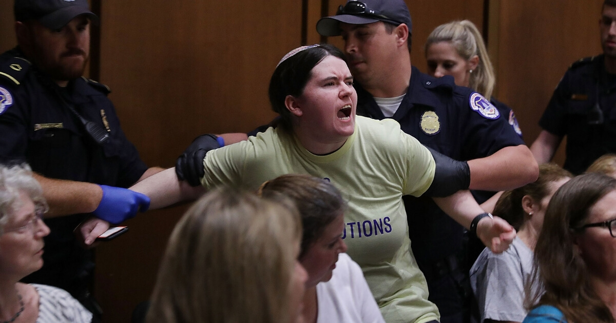 Capitol Police remove a protester from the hearing room during the second day of Supreme Court nominee Judge Brett Kavanaugh's confirmation hearing