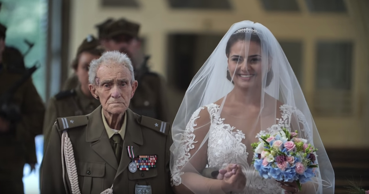 WWII veteran walks with his granddaughter in her wedding dress.