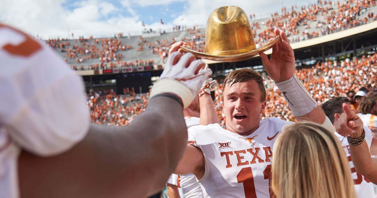 Texas quarterback Sam Ehlinger (11) holds the Golden Hat as he celebrates with teammates after defeating Oklahoma 48-45 Saturday at the Cotton Bowl in Dallas.