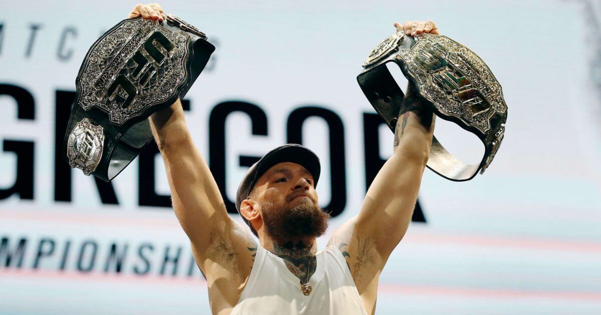 Conor McGregor holds up championship belts during a news conference for the UFC 229 mixed martial arts bouts Thursday in Las Vegas.
