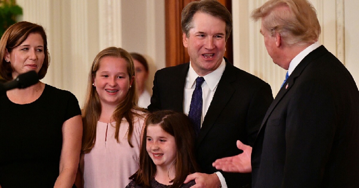 Supreme Court nominee Brett Kavanaugh shares a moment with President Donald Trump after Kavanuagh's nomination was announced July 9. With Kavanaugh are his wife, Ashley, and daughters Margaret and Liza, at bottom.