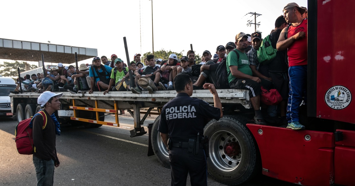 A Mexican Federal Police officer asks migrants to dismount from the crowded back of a truck in the Mexican state of Chiapas on Friday.