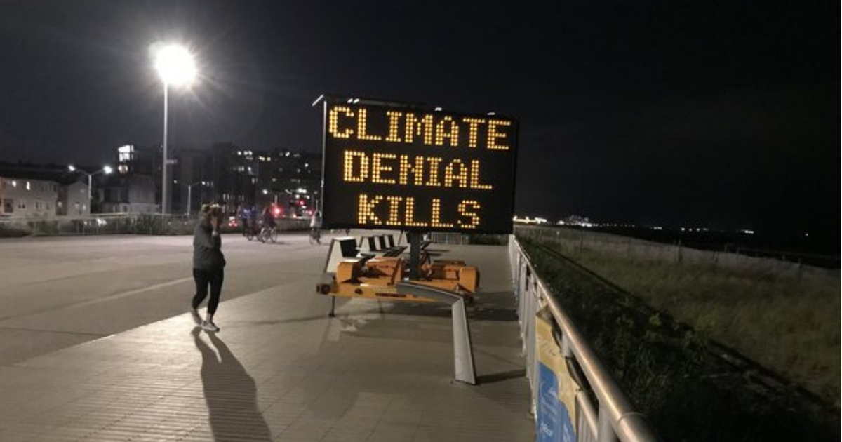 A sign on the Rockaway boardwalk in New York reads "Climate Denial Kills."