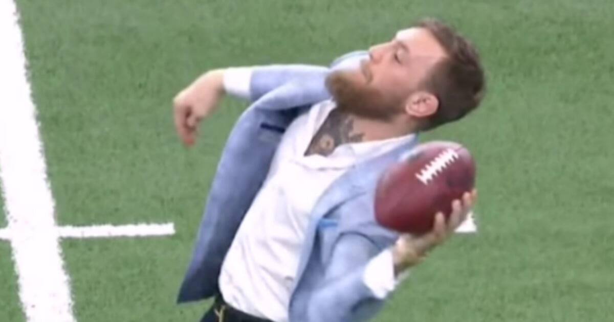 Conor McGregor attempts to throw a football while on the field at Cowboys Stadium on Sunday prior to the game between Dallas and Jacksonville.