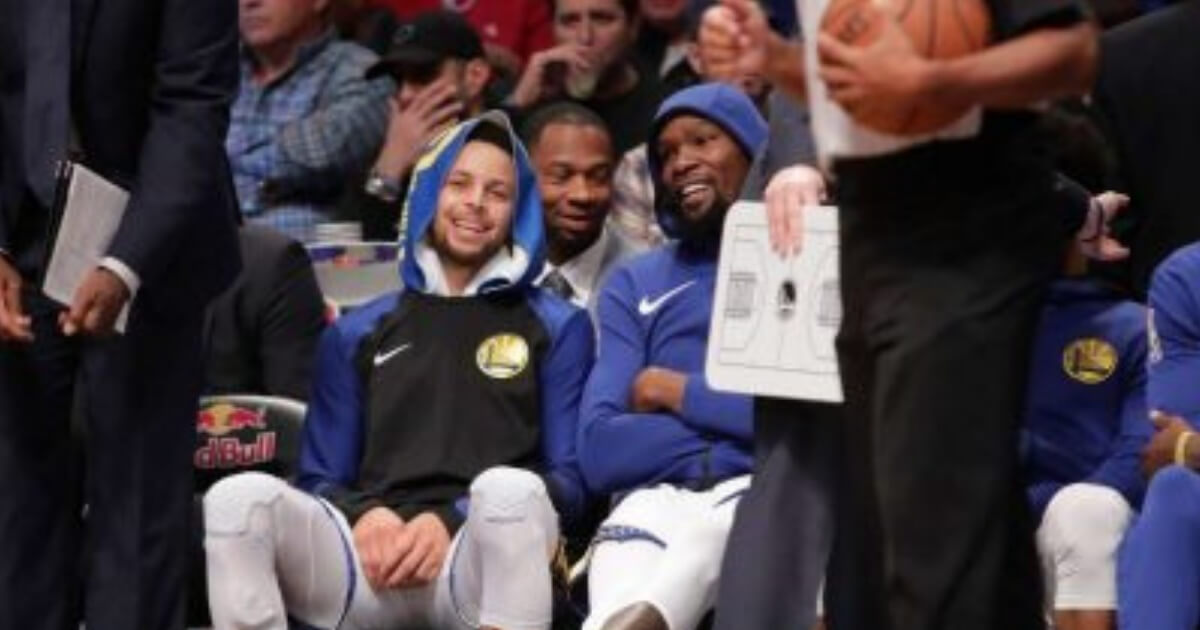 Stephen Curry, left, and Kevin Durant smile during the first half of Golden State's game at Brooklyn on Sunday.
