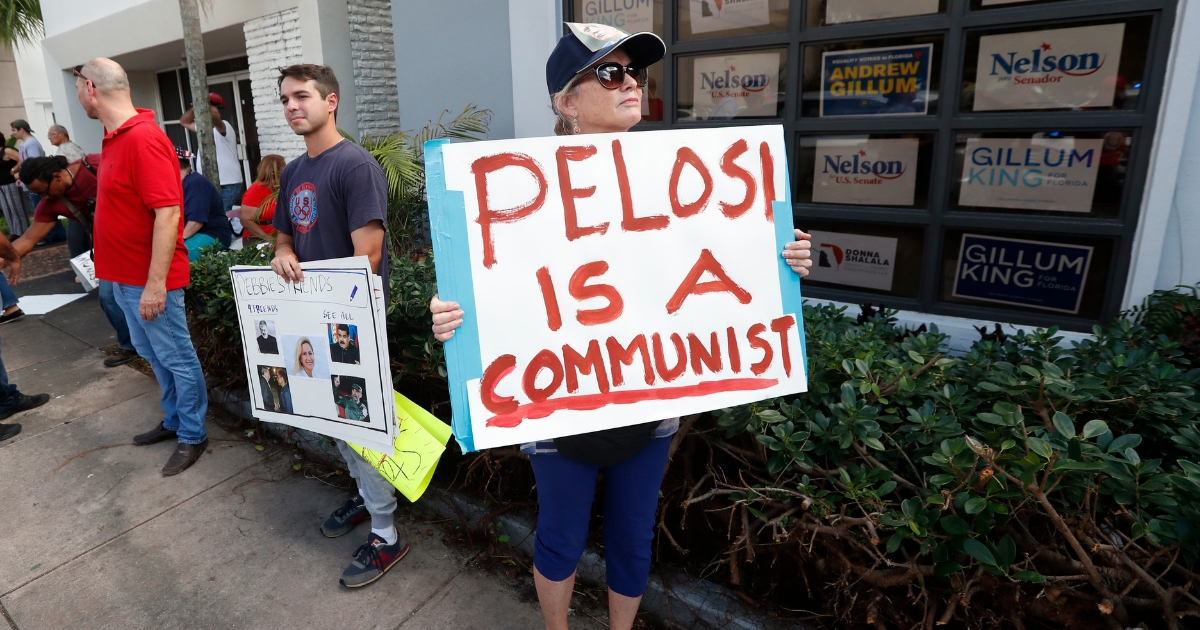 Demonstrators stand outside a building where House Minority Leader Nancy Pelosi spoke to volunteers at a get out the vote event for Florida Democratic congressional candidates Donna Shalala and Debbie Mucarsel-Powell, Wednesday, Oct. 17, 2018, in Coral Gables, Fla.