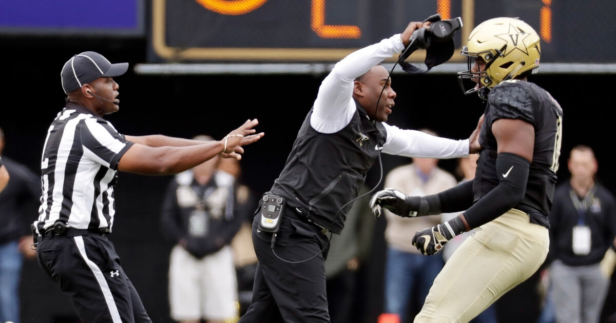 Vanderbilt head coach Derek Mason pushes defensive lineman Dayo Odeyingbo (10) off the field during a confrontation between Vanderbilt and Florida in the first half of Saturday's game in Nashville, Tennessee.