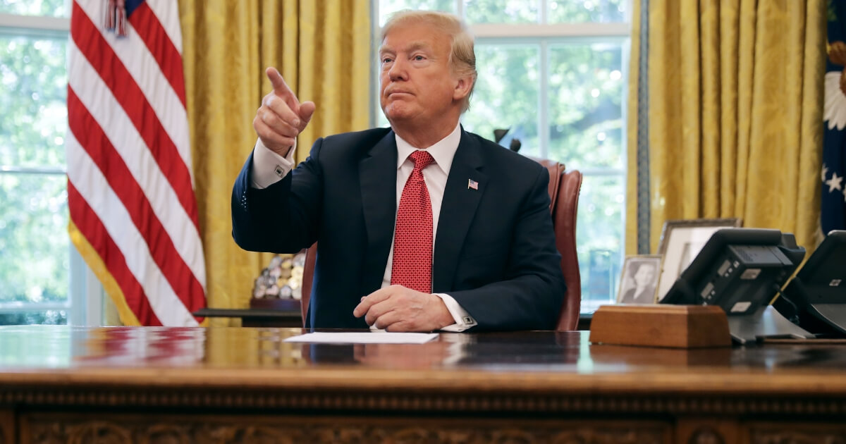 U.S. President Donald Trump calls on reporters while hosting workers and members of his cabinet for a meeting in the Oval Office at the White House Oct. 17, 2018 in Washington, D.C.