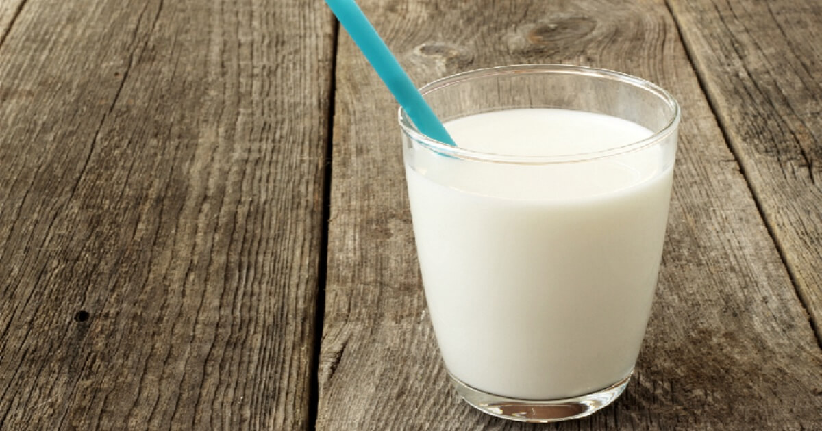 Glass of milk on wooden table.