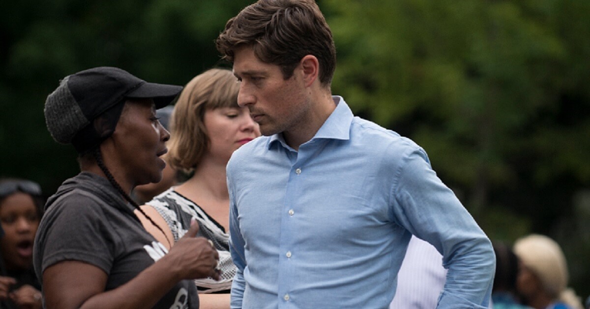 Minneapolis Mayor Jacob Frey talks to a constituent at a candlelight vigil for a man shot by police officers in June.