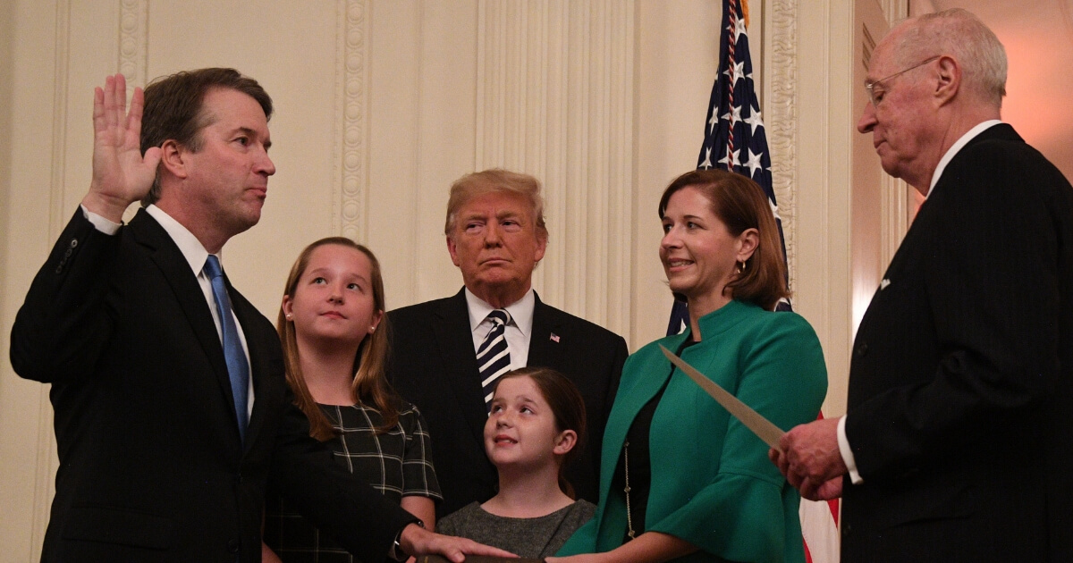 Brett Kavanaugh is sworn in as an associate Supreme Court justice by retiring Justice Anthony Kennedy while his wife, his daughters and President Donald Trump look on Saturday.