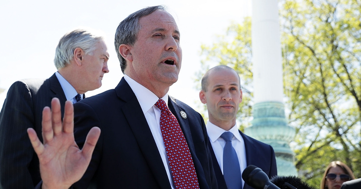 Texas Attorney General Kenneth Paxton speaks to members of the media as Texas Solicitor General Scott Keller (R) listens in front of the U.S. Supreme Court April 18, 2016, in Washington, D.C.