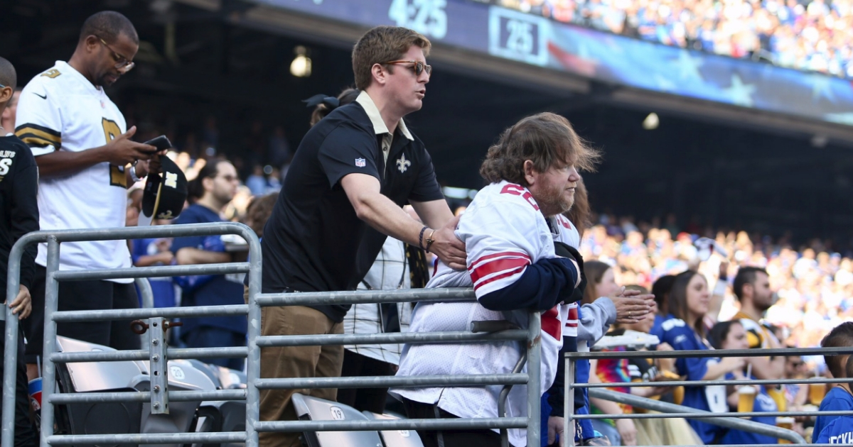 Man Helps Disabled Fan Stand for Anthem