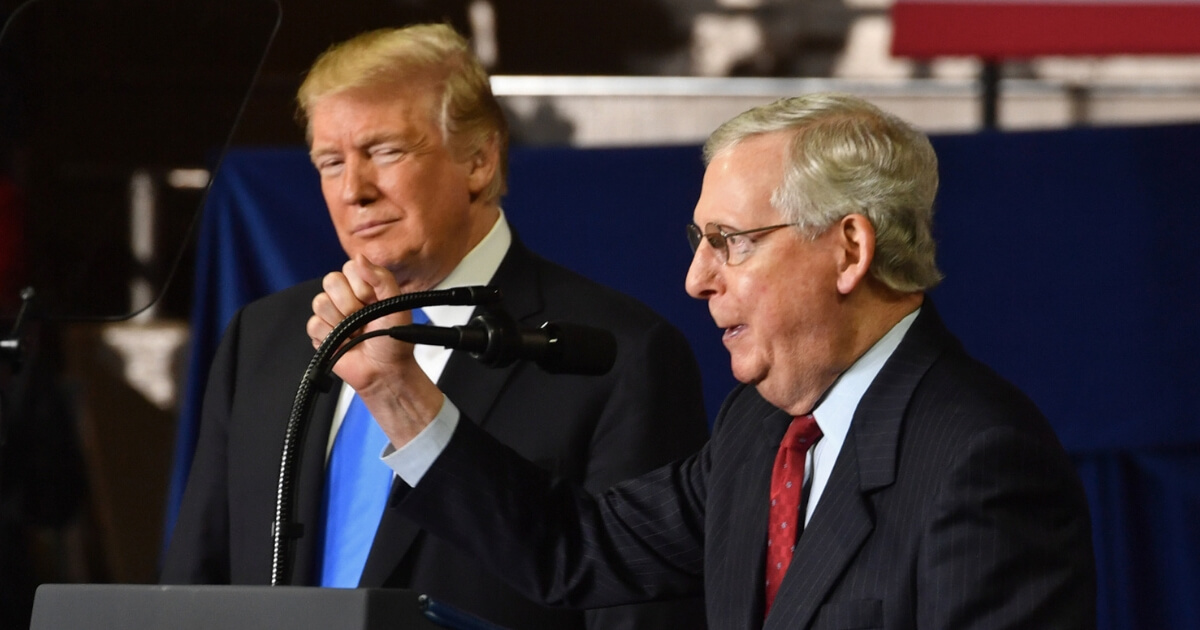 US Senate Majority Leader Mitch McConnell (R-KY) speaks as US President Donald Trump looks on