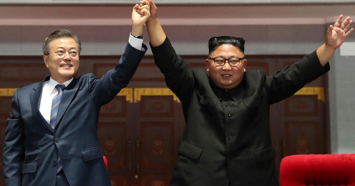 South Korean President Moon Jae-in and North Korean leader Kim Jong Un hold and raise their hands